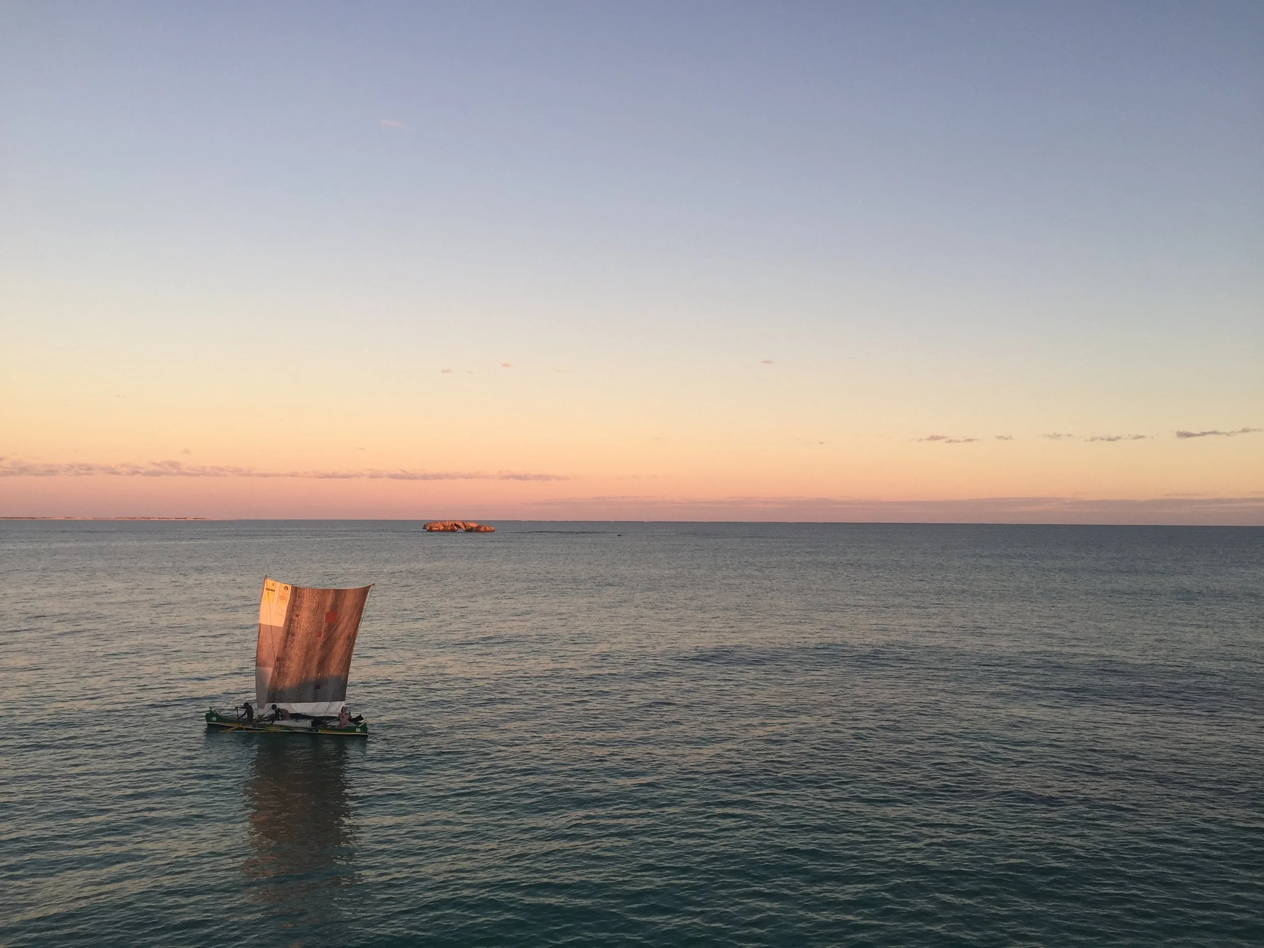 Dhow sailing boat on calm water at sunset in Madagascar